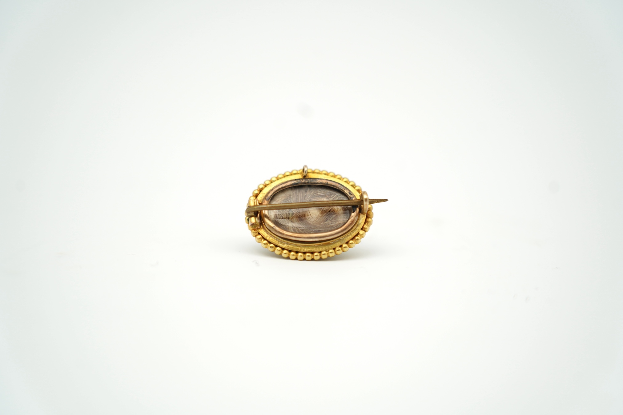 A Victorian yellow metal, turquoise and seed pearl set domed cluster mourning brooch, with plaited hair verso, 22mm. Condition - poor to fair